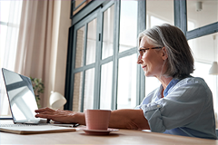 kyruus-sponsored-article photo of an older woman at a computer