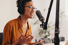 Podcasts photo of a young black woman recording a podcast